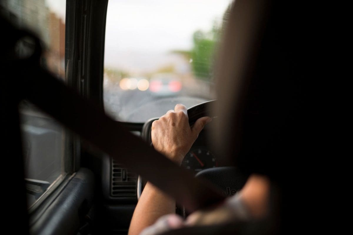aged woman caucasian people driving the car in the traffic with seat fasten belt
