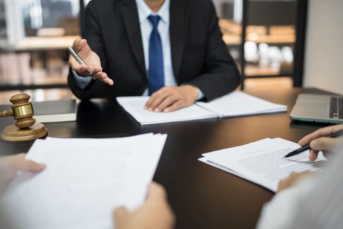 Legal counsel presents to the client a signed contract with gavel and legal law.